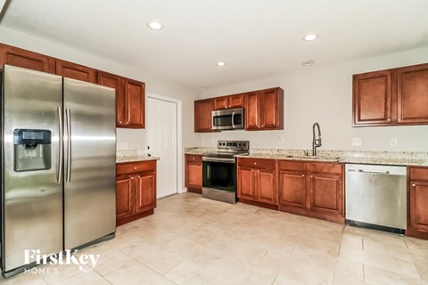A kitchen with wooden cabinets and a refrigerator.