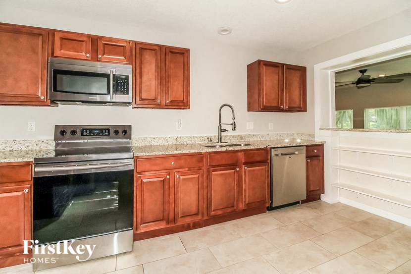 A kitchen with brown cabinets and a stainless steel oven.