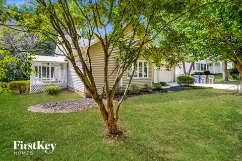a home with a tree in the front yard