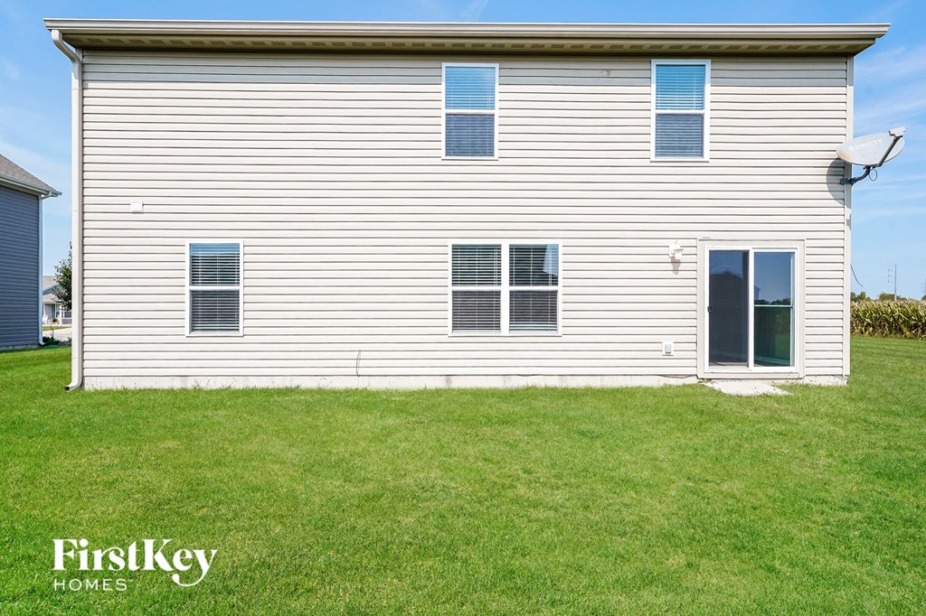 a side view of a white house with white siding and green grass