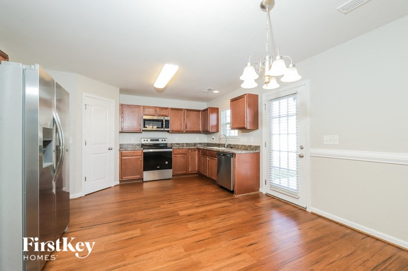 a kitchen with wood flooring and wooden cabinets and stainless steel appliances