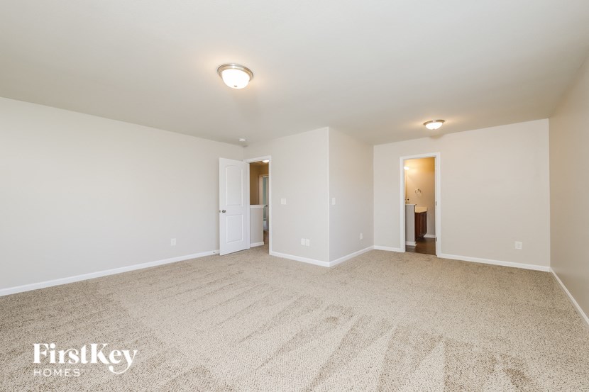 a spacious living room with carpet and white walls