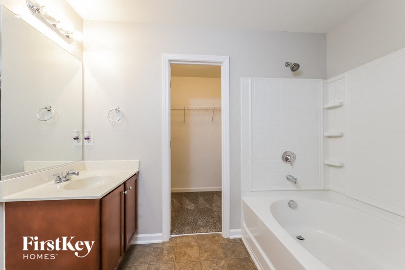 a bathroom with a tub and a sink and a mirror