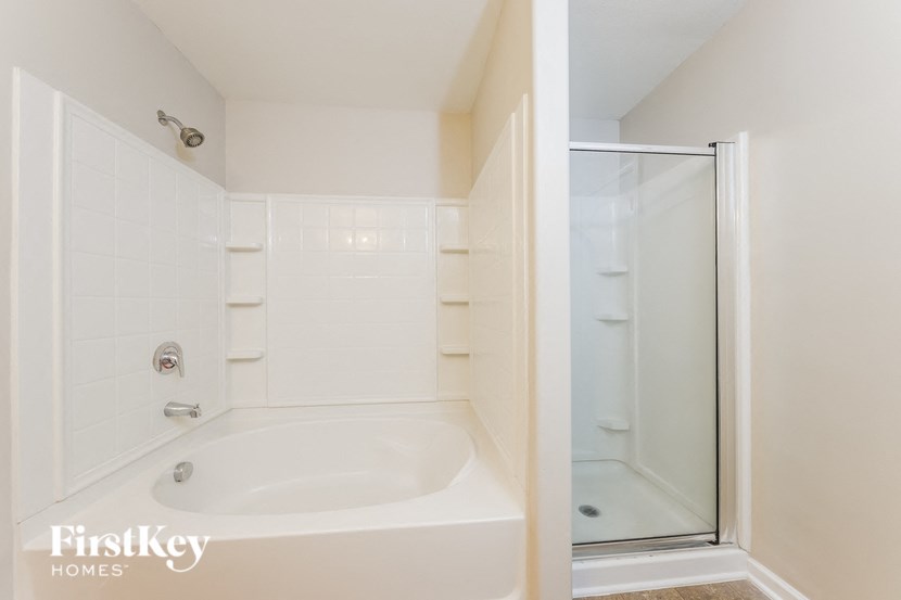 a white bathroom with a tub and a shower