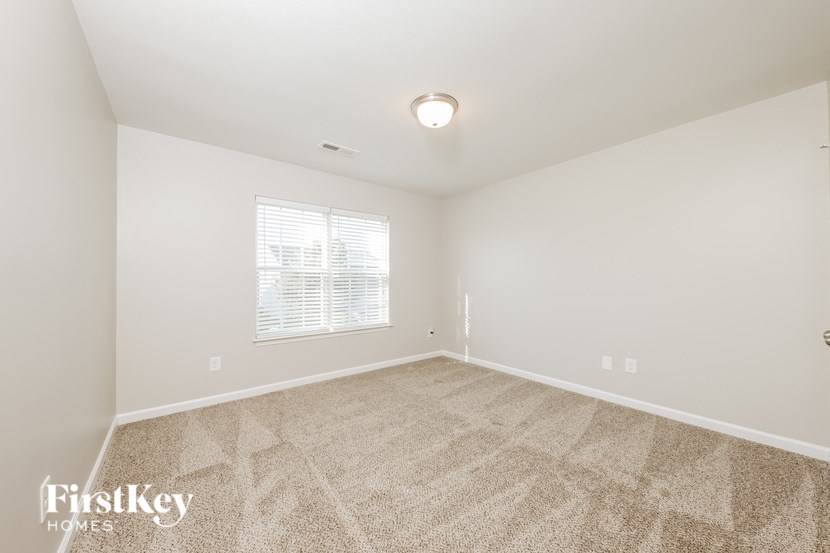 a spacious living room with carpet and a window
