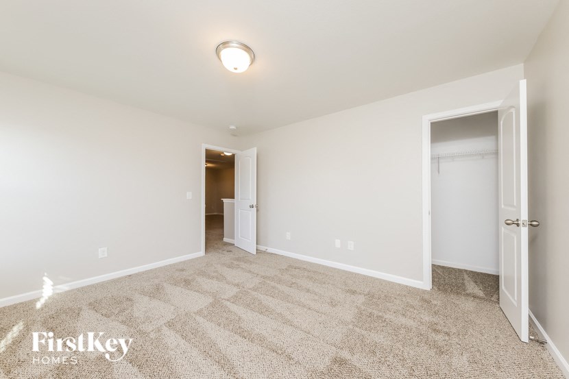 a spacious living room with carpet and a door to a closet
