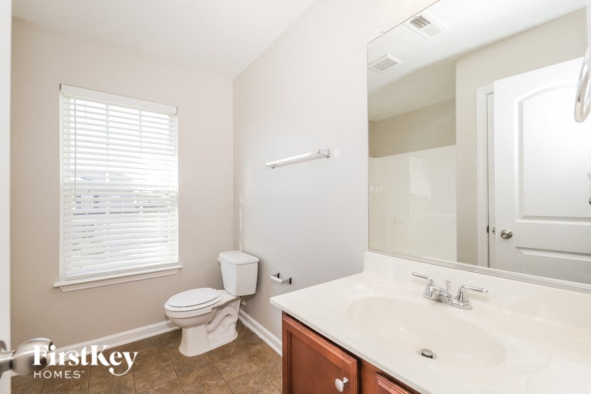 a bathroom with a toilet and a sink and a mirror