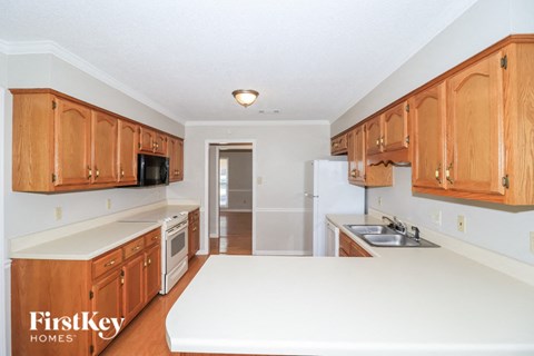 a kitchen with white counters and wooden cabinets and a white counter top