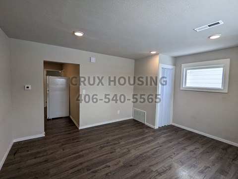 a living room with a hard wood floor and a window