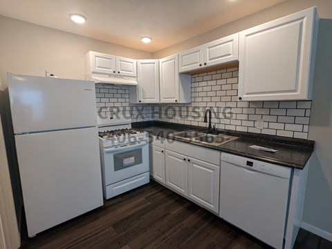 a kitchen with white cabinets and a stove and refrigerator