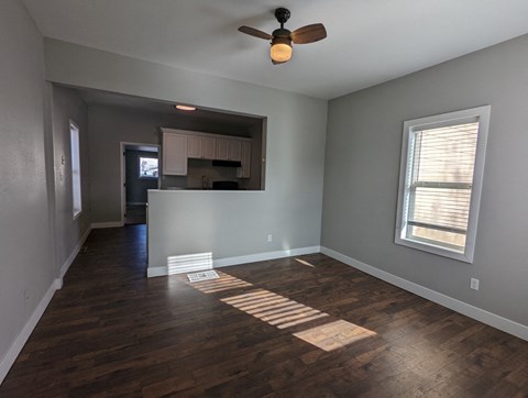 a living room with wood floors and a ceiling fan
