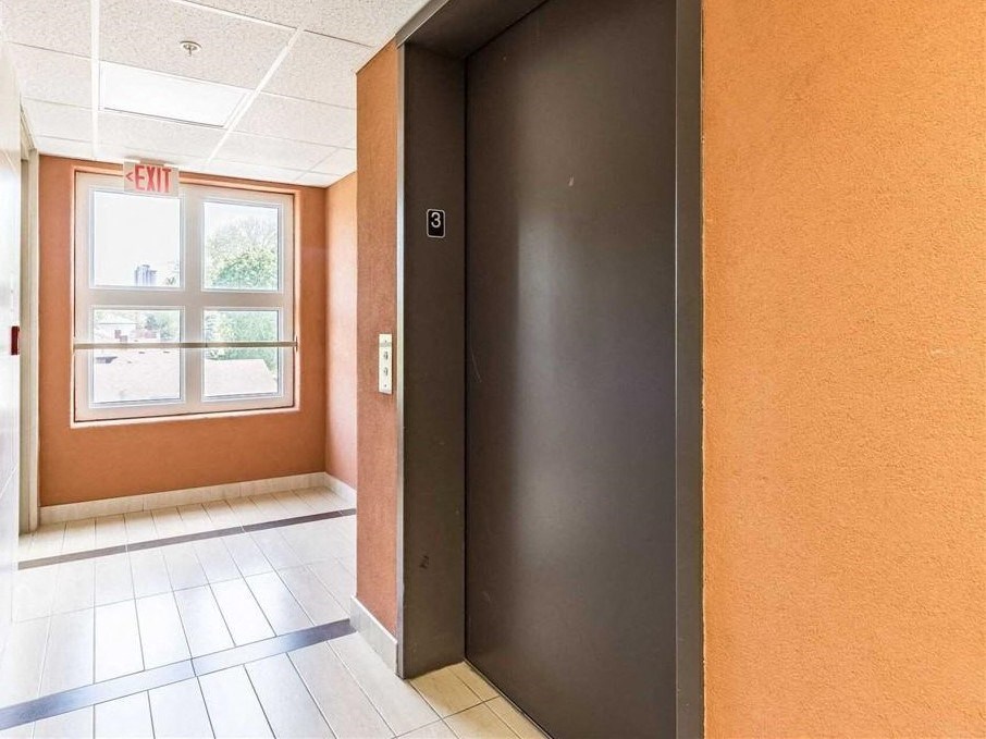 an empty room with a black door and a window