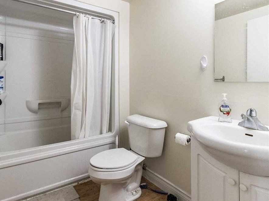 a white bathroom with a toilet and a sink