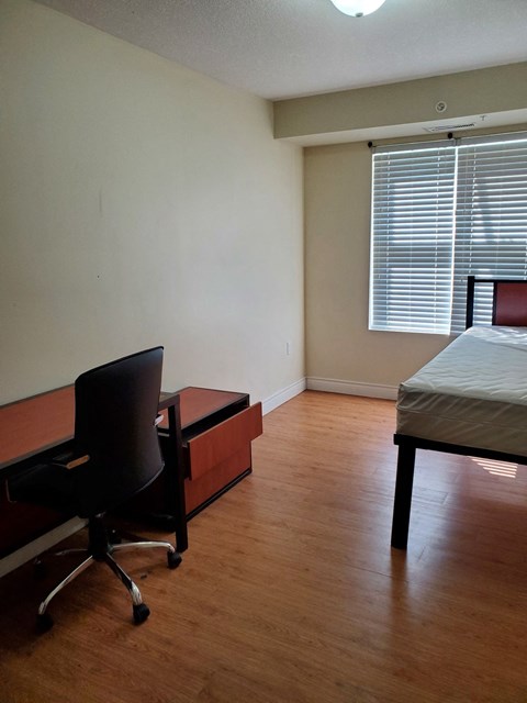 a bedroom with a bed and a desk and a chair