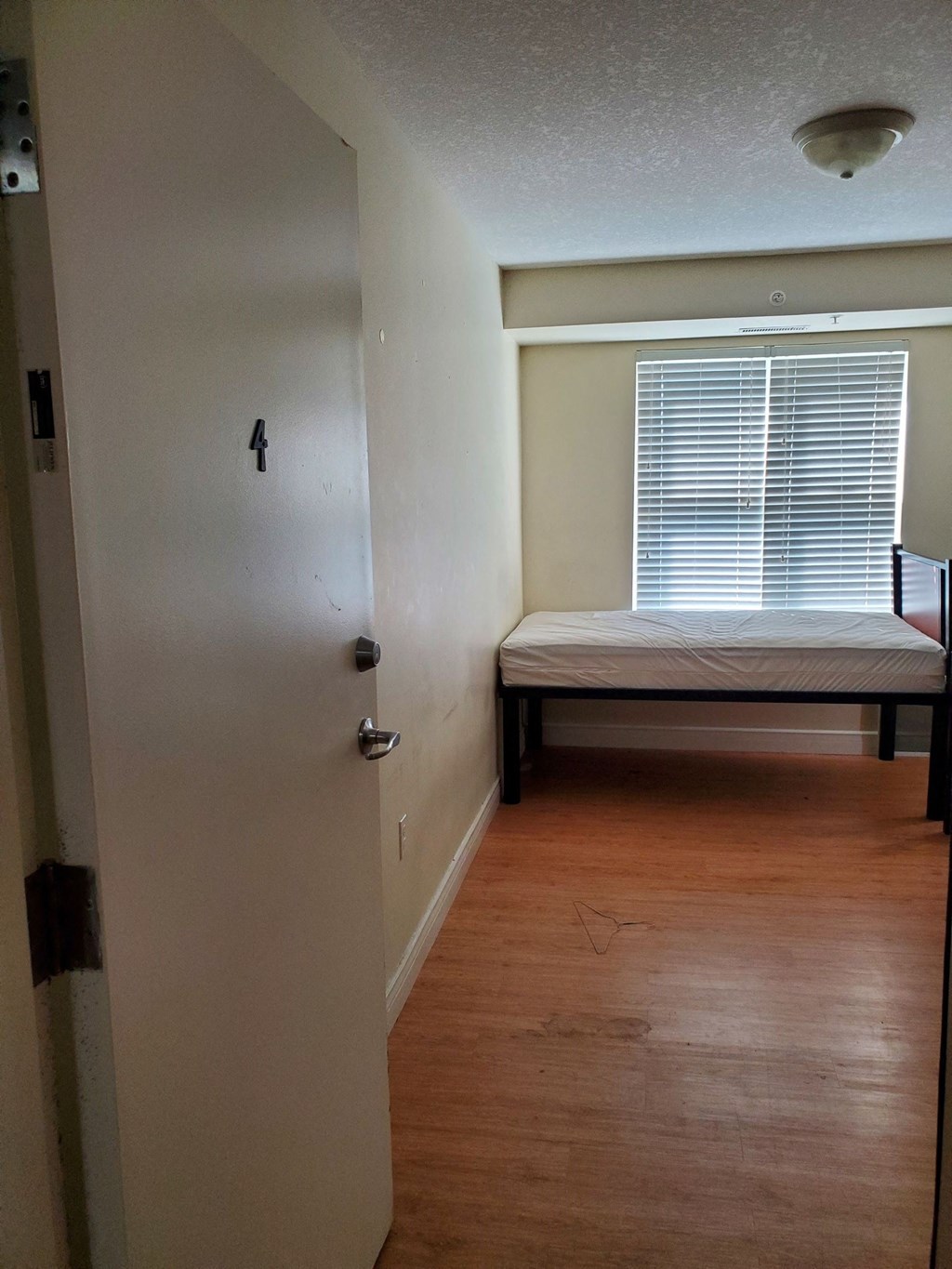 an empty room with a bed and a window