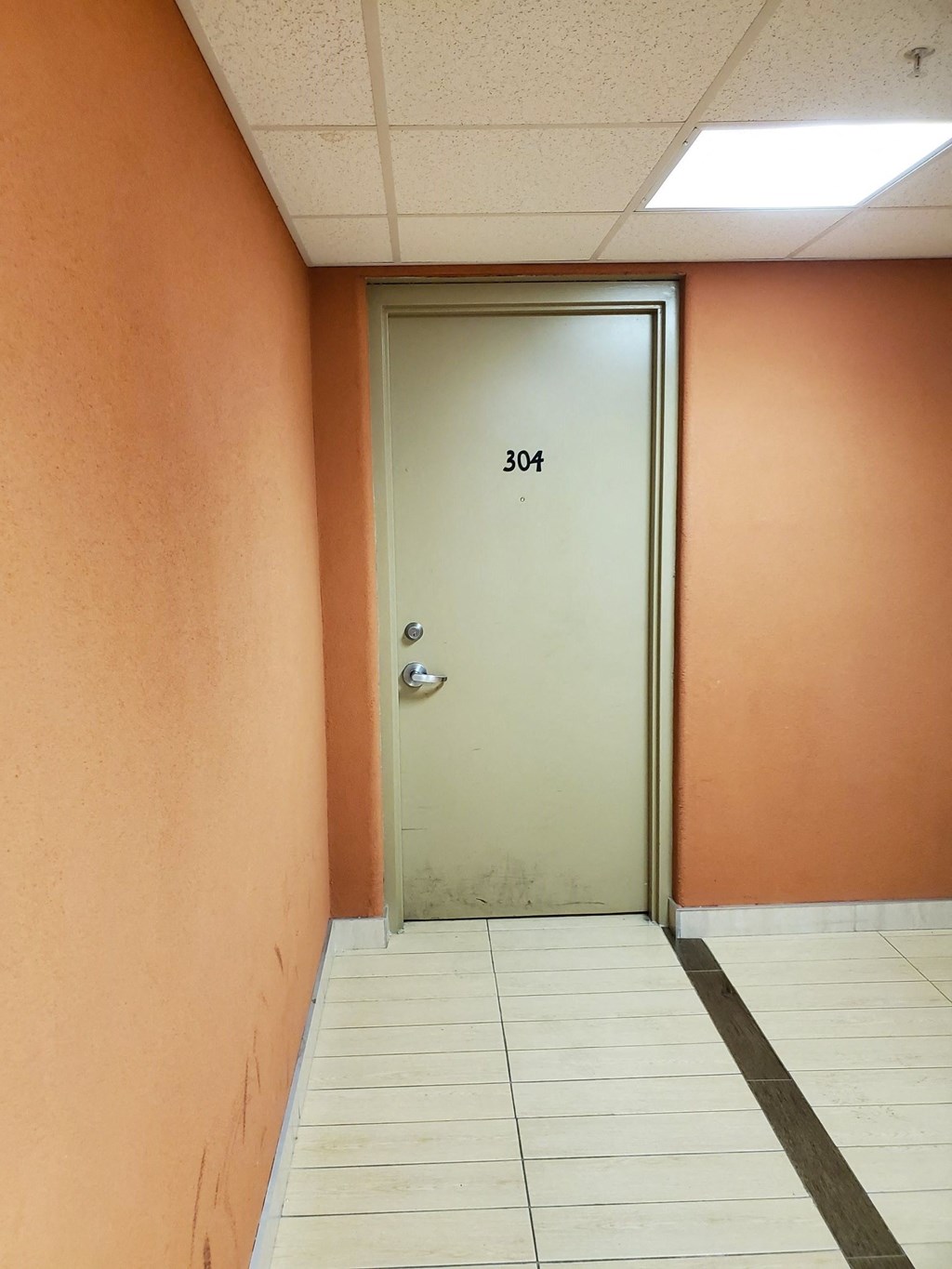 an empty hallway with a door with the number 301 on it