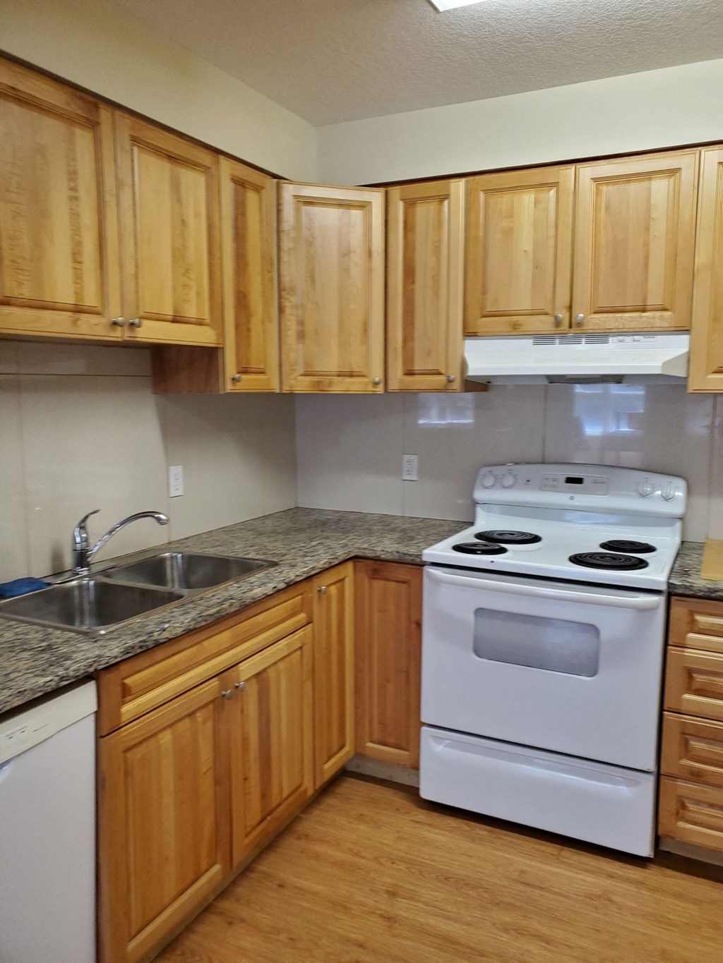 a kitchen with wooden cabinets and a stove and a sink
