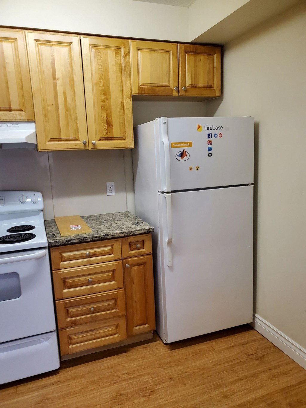 a kitchen with a refrigerator and stove and wooden cabinets