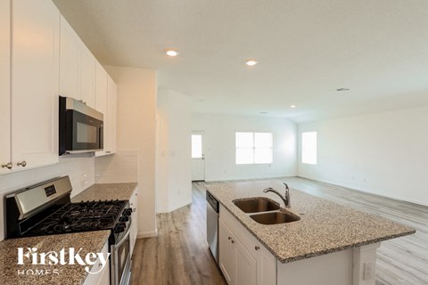 A kitchen with granite countertops and a stove top oven.