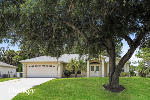 a house with a garage and a tree in the yard