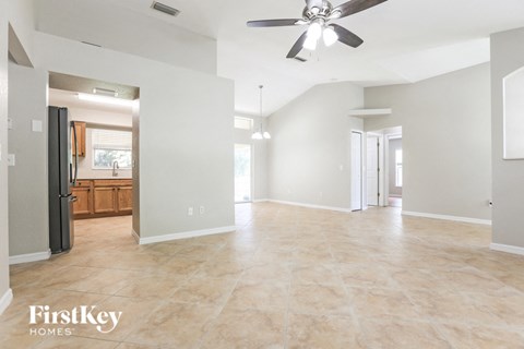 an empty kitchen and living room with a ceiling fan