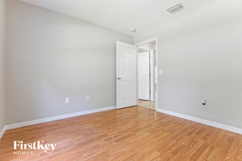 a living room with a hard wood floor and a white door