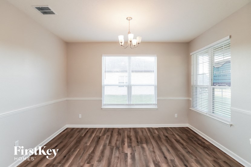 a dining room with a wood floor and a window