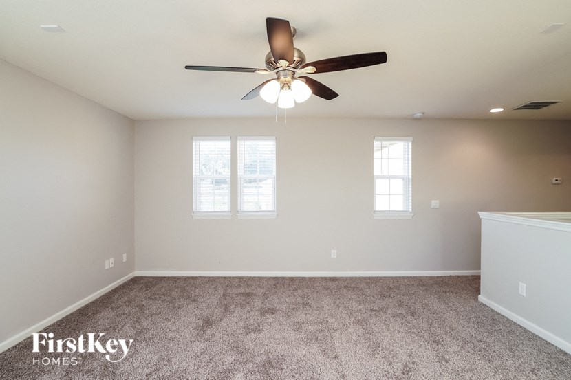 a bedroom with a ceiling fan and a carpeted floor