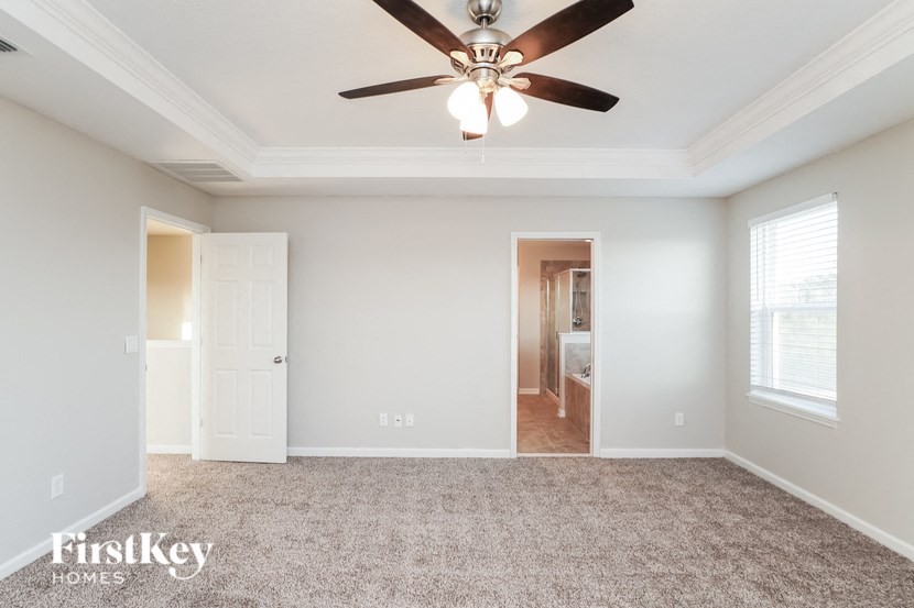an empty living room with a ceiling fan