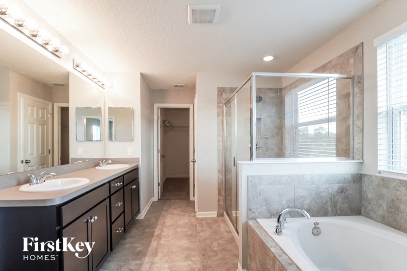 a bathroom with two sinks and a tub and a shower