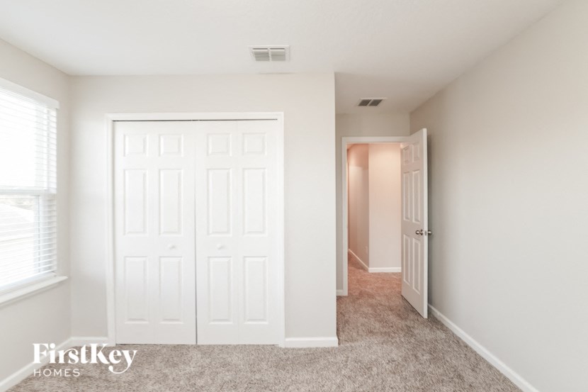 a bedroom with a closet and a door to a hallway