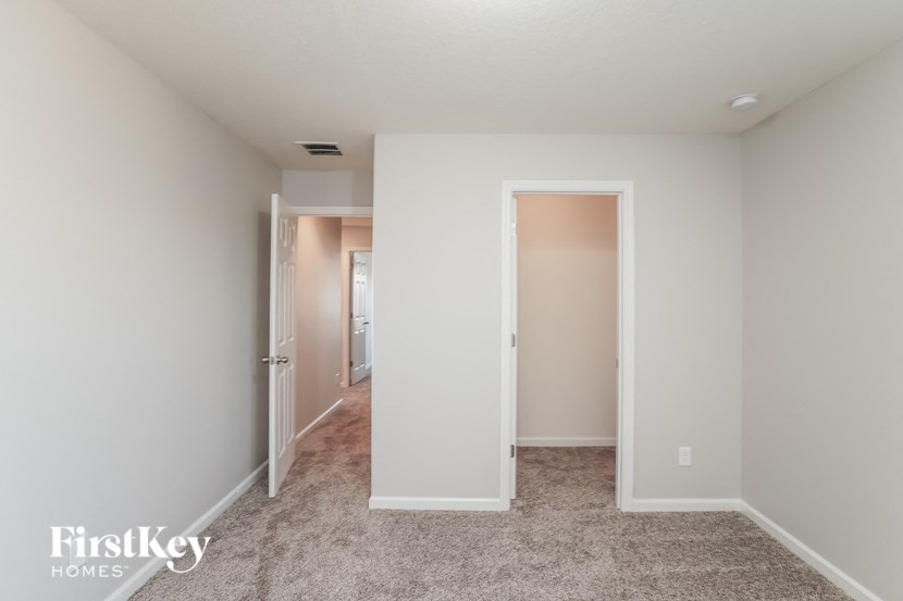 a bedroom with a door to a hallway and a carpeted floor