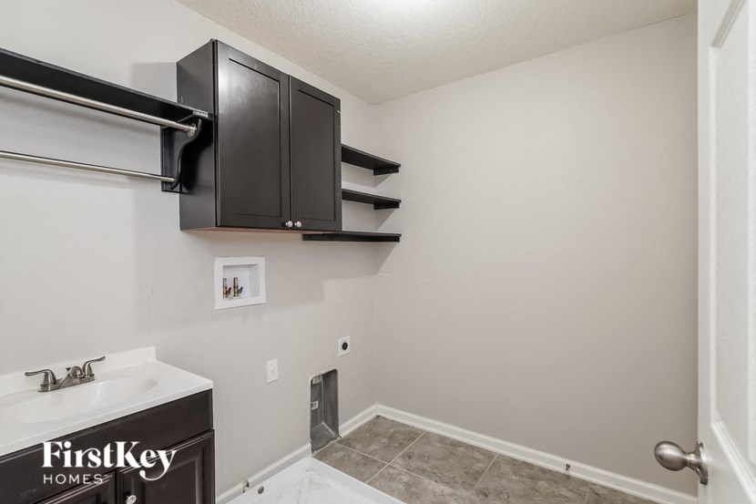 a bathroom with black cabinets and a white sink and a shower
