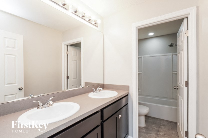a bathroom with two sinks and a mirror and a shower