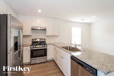 A kitchen with a stainless steel refrigerator, stove, and dishwasher.