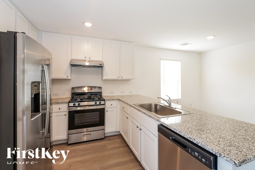 A kitchen with a stainless steel refrigerator, stove, and dishwasher.