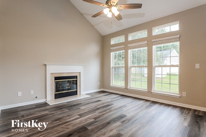 A spacious room with a fireplace and a ceiling fan.