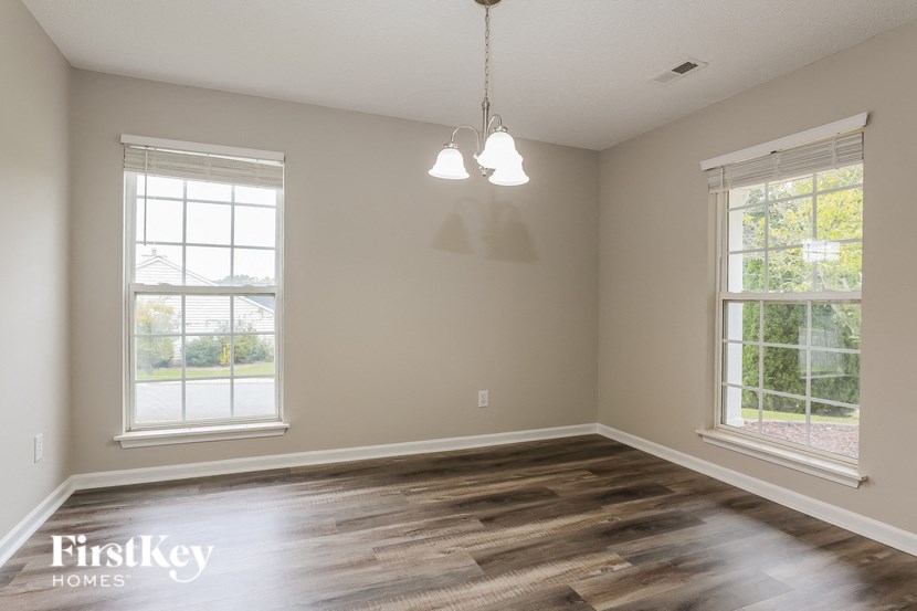 A room with wooden floors and two windows.