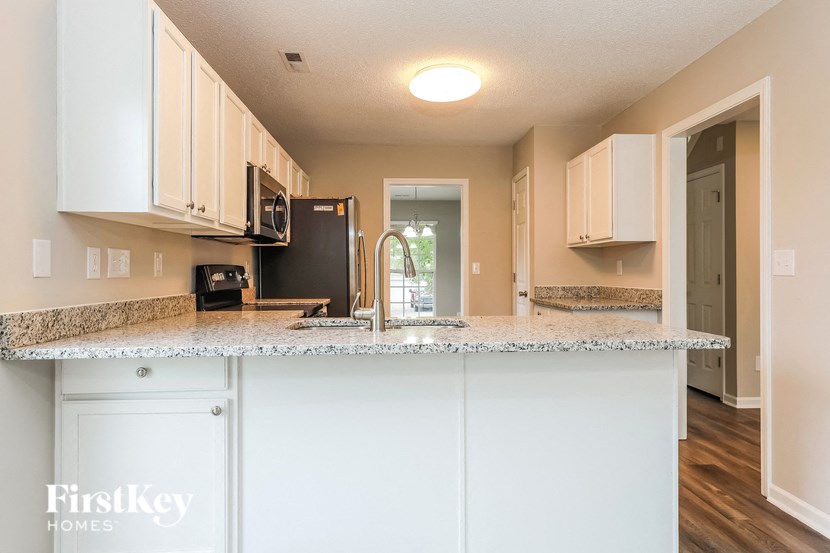 A kitchen with a granite countertop and white cabinets.