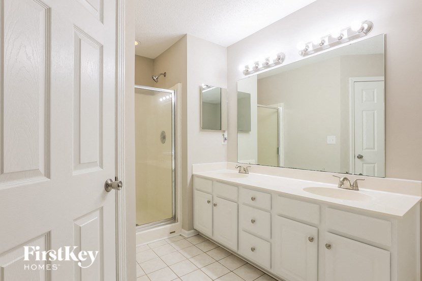 A bathroom with a white sink and a mirror above it.