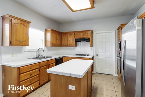 A kitchen with wooden cabinets and a white countertop.