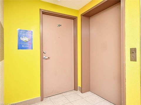 A yellow wall with a brown door and a sign on the wall.