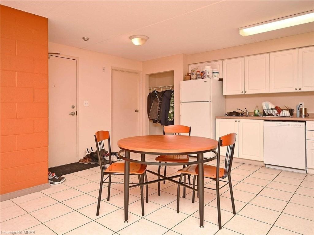A kitchen with a table and chairs in the foreground and a refrigerator in the background.