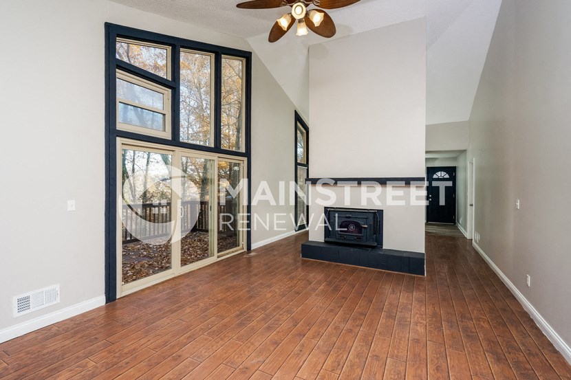a living room with a wood floor and a fireplace