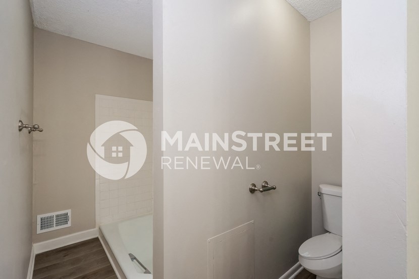a renovated bathroom with a toilet and a tub and a shower