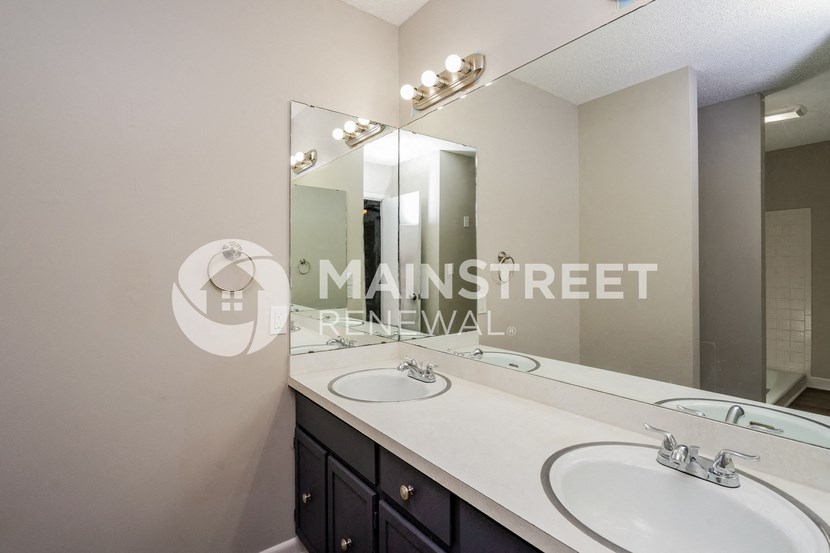 a bathroom with two sinks and a large mirror