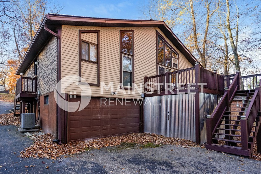 a small house with a garage and stairs
