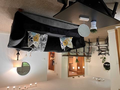 a living room with a bunch of clothes hanging from the ceiling