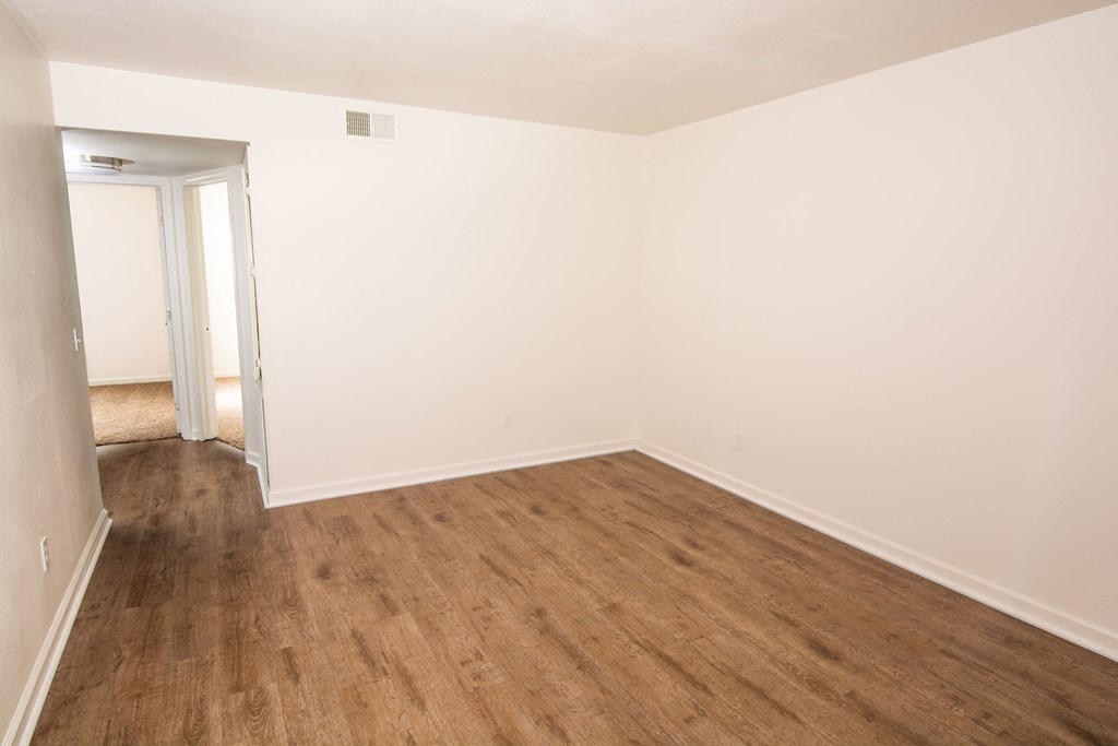 an empty room with white walls and wooden floors