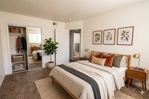 A bedroom with a large bed and a mirror on the wall.